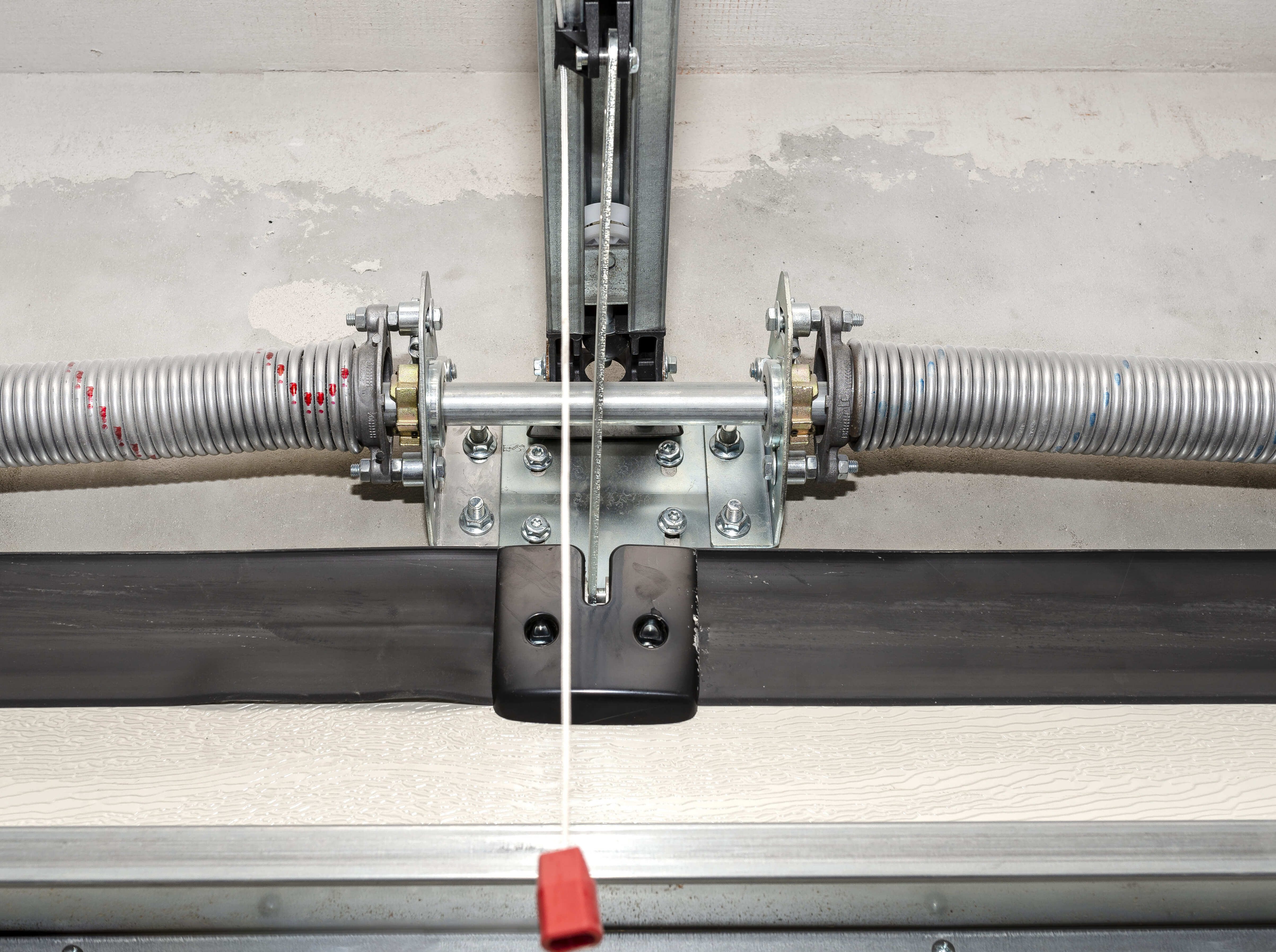 Technician balancing a garage door spring system for safe movement