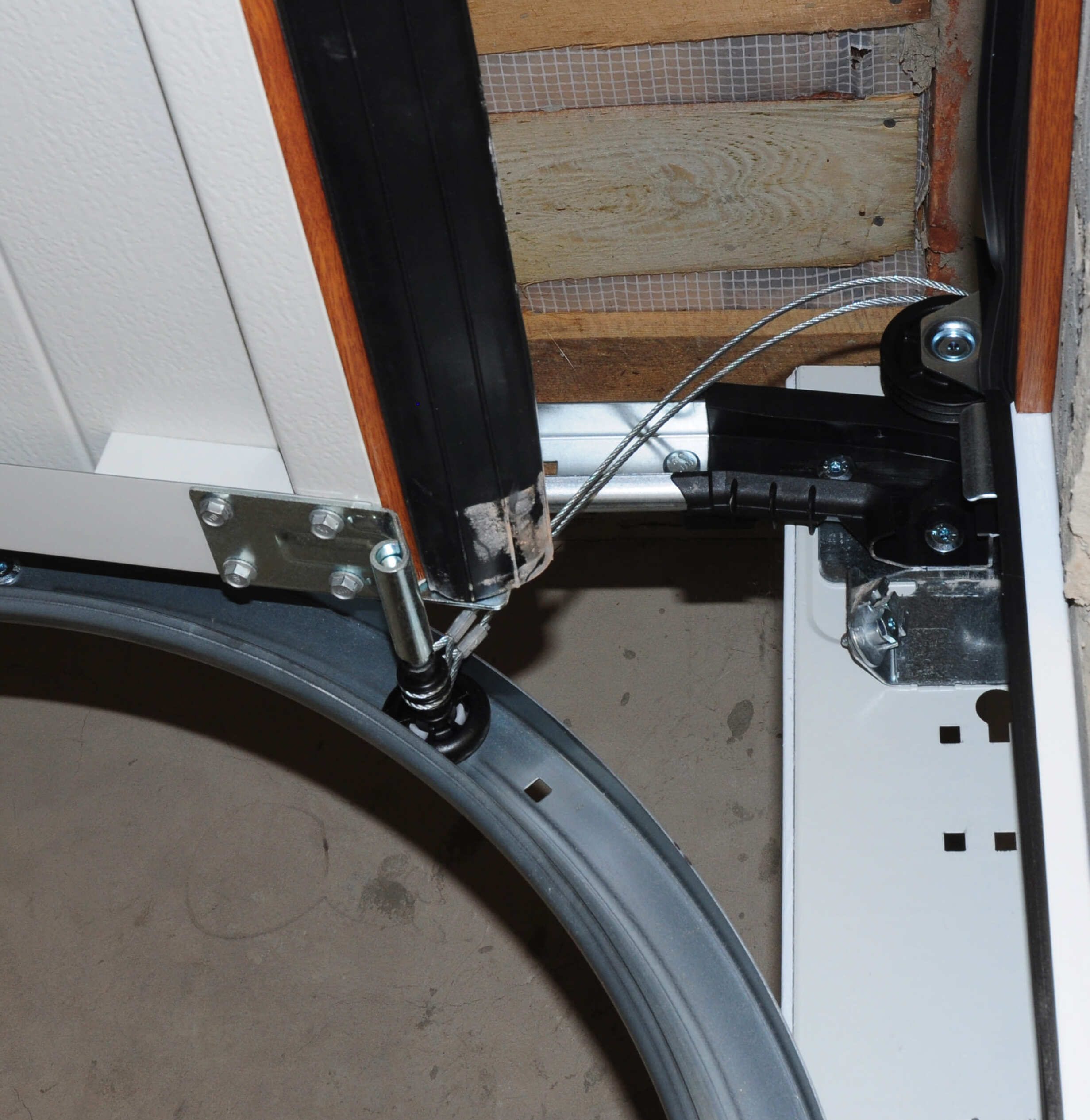 Garage door cable repair and drum alignment service in progress