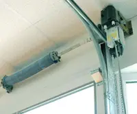 Direct-drive jackshaft opener mounted beside garage door