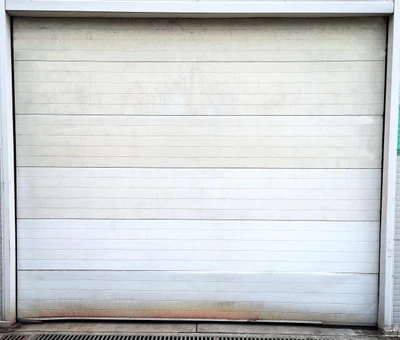 Professional garage door technician removing and replacing damaged garage door panel sections, showing expert panel replacement service to restore structural integrity, weather sealing, and enhanced curb appeal for Cincinnati residential properties