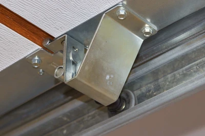 Professional garage door technician installing new nylon rollers and hinges showing expert hardware replacement service with precision tools to reduce noise, improve smooth operation, and extend garage door system lifespan for Cincinnati homeowners